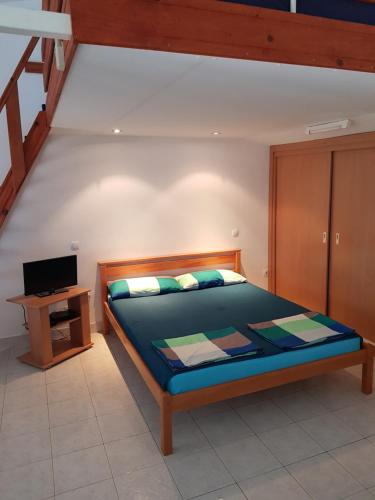 a bedroom with a bed and a desk with a television at Vila Familija in Dobra Voda
