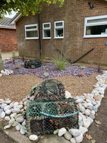 a garden with a net and rocks in front of a house at Beach House in Filey