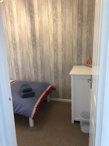 a small bedroom with a bed and a desk at Beach House in Filey