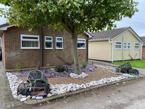 a garden with rocks and a tree in front of a house at Beach House in Filey