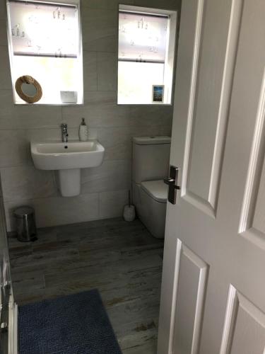a bathroom with a sink and a toilet and a window at Beach House in Filey