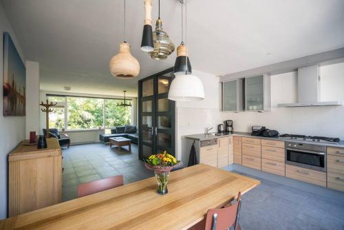 a kitchen with a wooden table with a vase of flowers on it at CityHouse Alkmaar in Alkmaar