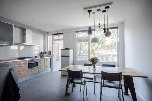 a kitchen with a wooden table and chairs in a kitchen at CityHouse Alkmaar in Alkmaar