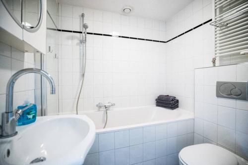 a bathroom with a tub and a sink and a toilet at CityHouse Alkmaar in Alkmaar