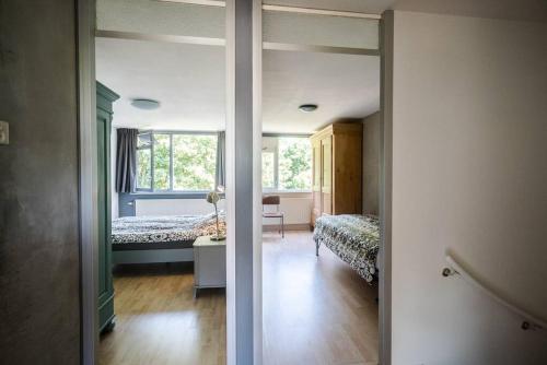 a room with a bedroom with a bed and a mirror at CityHouse Alkmaar in Alkmaar