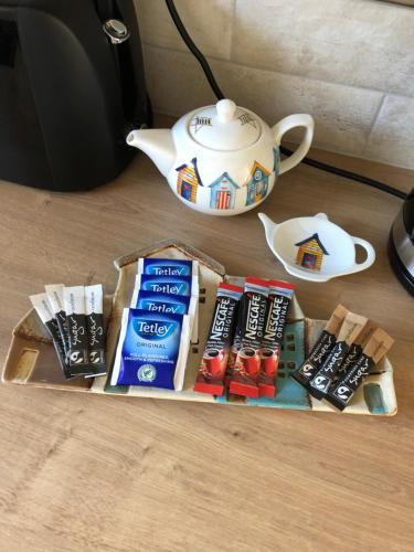 a table with a teapot and a tray of food at Beach House in Filey