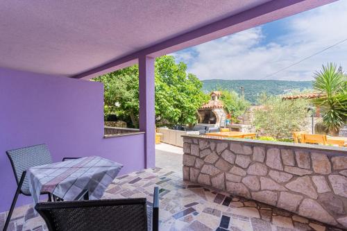a balcony with a table and chairs and a stone wall at Villa Lavanda in Cres