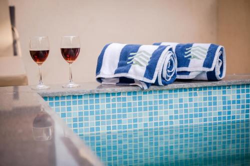 two glasses of wine and towels on a ledge at Villa Amara 29 by Stay ALYF, Lonavala in Lonavala