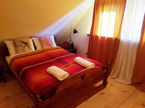 a bedroom with a bed with two towels on it at Wiedźminowo in Włodawa