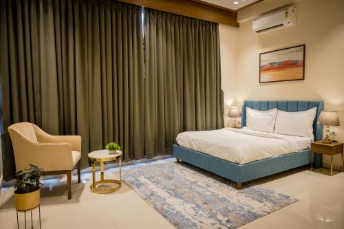 a hotel room with a bed and a chair at Villa Amara 29 by Stay ALYF, Lonavala in Lonavala
