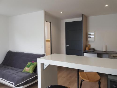 a kitchen and a living room with a couch at Guest House entre ville et océan in La Rochelle