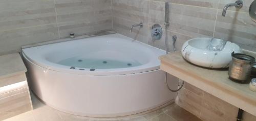 a bath tub in a bathroom with a sink at EVA'S HOME in Bizerte