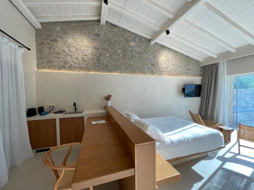 a bedroom with a bed and a desk in it at Melitsina Village Hotel in Kardamili