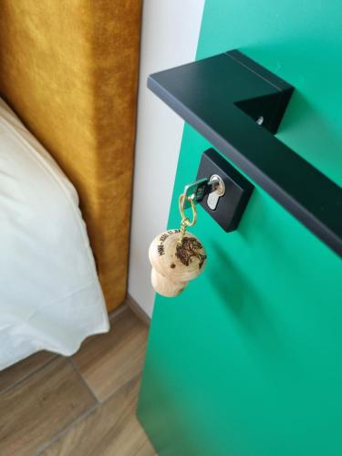 a green bedside table with a key on it at Cerf, ouvre-moi B&B in Rochefort