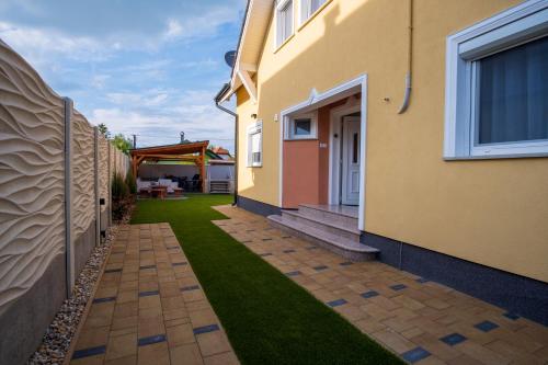 a yard with green grass next to a building at LuxVil Apartman in Balatonkeresztúr