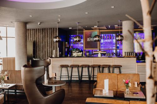 a restaurant with a bar with chairs and tables at Mercure Hotel Hamburg City in Hamburg