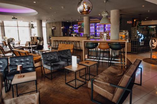 a bar in a restaurant with chairs and tables at Mercure Hotel Hamburg City in Hamburg