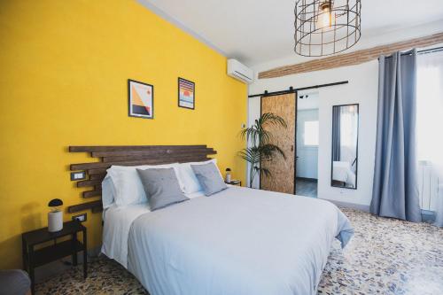 a bedroom with a white bed and a yellow wall at Nonna Gina Country House in San Miniato Basso