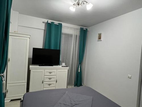 a bedroom with a bed and a television on a dresser at Apartament Craiova Magnolia in Craiova