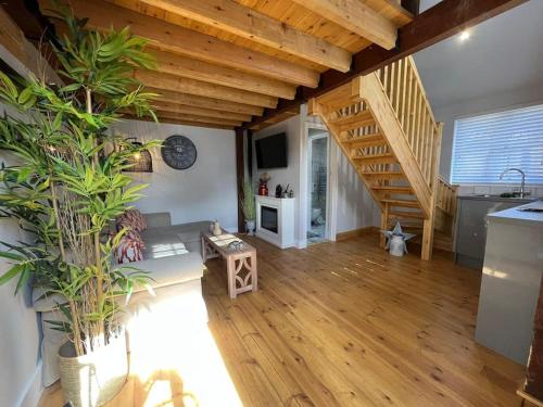 a living room with wooden ceilings and a staircase at The Shack - Thatched Self Contained Annex in Collingbourne Ducis