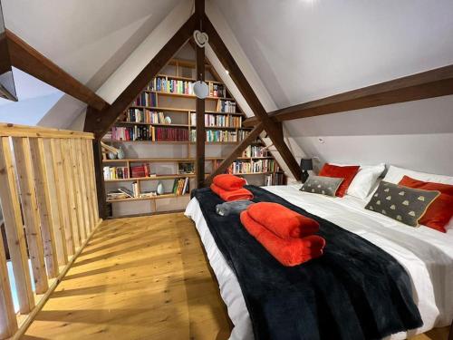 um quarto no sótão com uma cama grande e cobertores vermelhos em The Shack - Thatched Self Contained Annex em Collingbourne Ducis