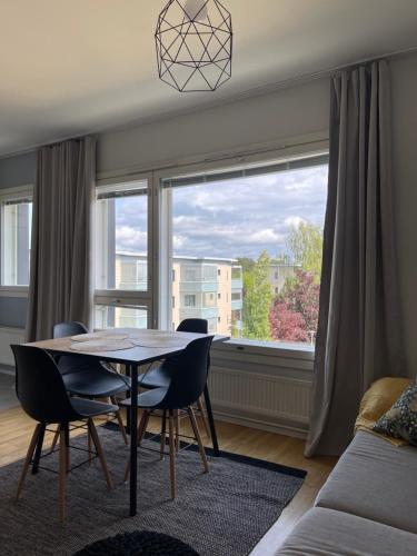 een woonkamer met een tafel en stoelen en een raam bij Casa Marina Naantali in Naantali