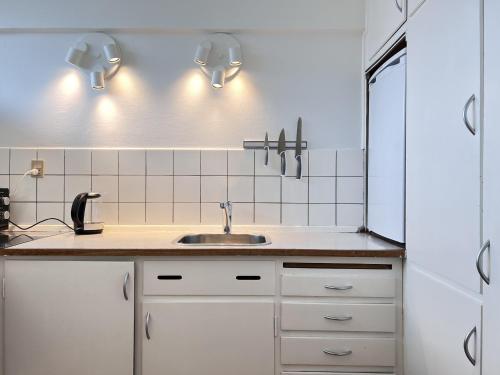 cocina con fregadero y luces en la pared en One Bedroom Apartment In Rdovre, Trnvej 41b, 2, en Rødovre