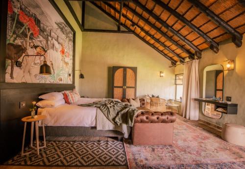 Okapuka Safari Lodge في ويندهوك: غرفة نوم بسرير وجدار جداري
