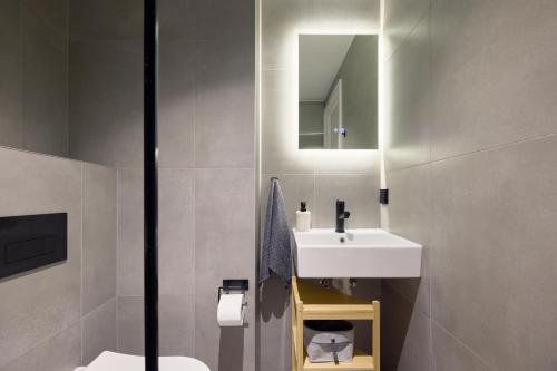 uma casa de banho com um lavatório branco e um espelho. em 21 Stylish Lofts by Dream Stay em Talin