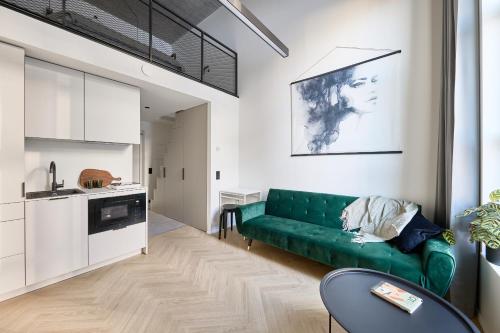 uma sala de estar com um sofá verde e uma cozinha em 21 Stylish Lofts by Dream Stay em Talin