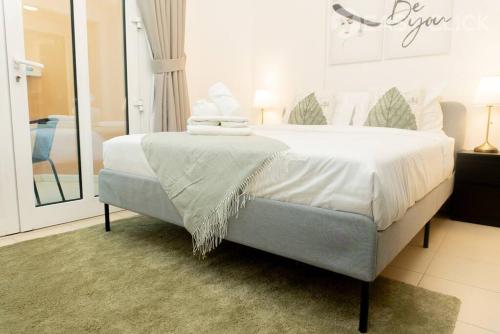 杜拜的住宿－Easy Click - Pocket Friendly & Trendy 1 Bed，一间卧室配有一张带白色床单和镜子的床