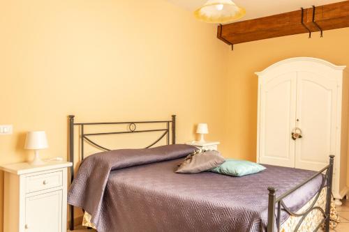 a bedroom with a bed with a purple blanket at Casa Adele - Cilento in Ceraso