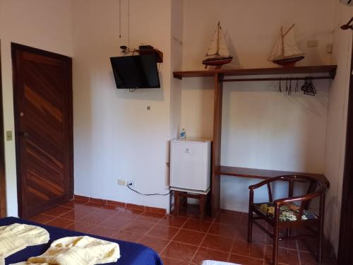 a room with a bed and a tv on the wall at Solar das Canoas Prumirim in Ubatuba