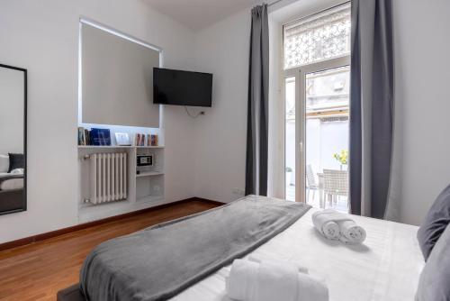 sypialnia z łóżkiem, telewizorem i oknem w obiekcie Art House Centro Storico Luxury Apartment w Rzymie