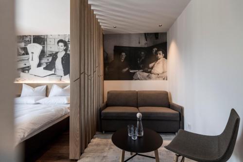 sypialnia z łóżkiem, kanapą i stołem w obiekcie Alpin & Stylehotel Die Sonne w mieście Parcines
