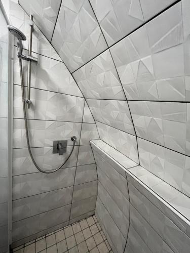 a shower in a bathroom with white tiled walls at SeaView Nicotera Marina in Nicotera Marina