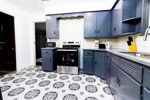 eine Küche mit blauen Schränken und Fliesenboden in der Unterkunft Cozy 5BR Home minutes from the falls in Niagara Falls