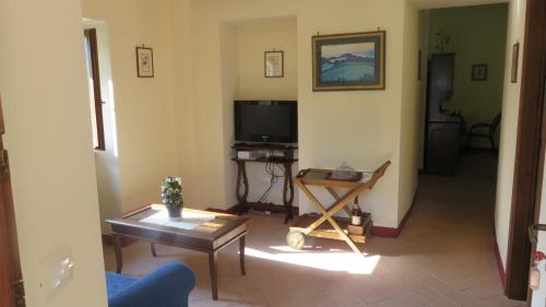 a living room with a television and a table at Agriturismo I Melograni in Ferentillo