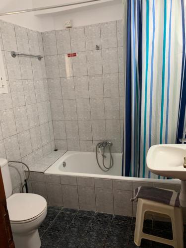 een badkamer met een bad, een toilet en een wastafel bij Agni in Nafpaktos