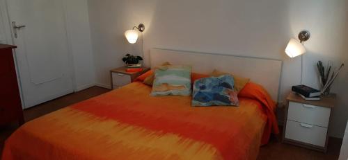 een slaapkamer met een groot oranje bed met 2 kussens bij Appartamento Viale Puccini - Free Gated Parking - 3 Minutes from Center in Lucca