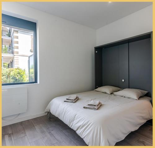 a bedroom with a large bed with two towels on it at Appartement Cozy 1 Panoramique Lac Léman Thonon-Les-Bains in Thonon-les-Bains