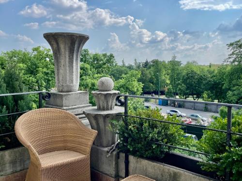 a chair on a balcony with a view of a street at Villa with terrace overlooking the city park in Budapest
