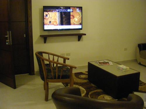 a living room with a chair and a tv at Ream Hotel Amman in Amman