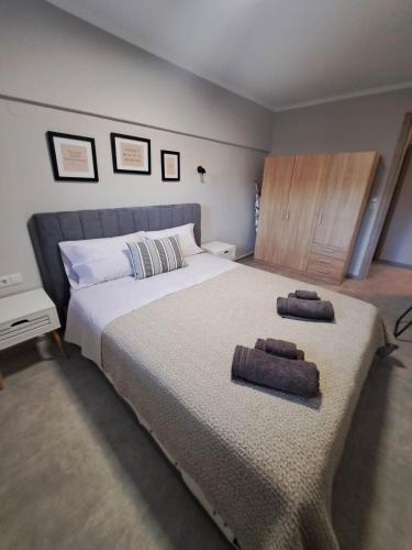 a bedroom with a large bed with two towels on it at Elegance apartment in Paleo Tsifliki