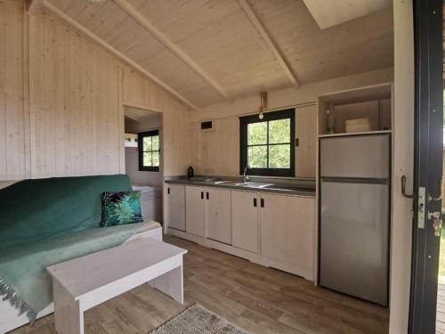 un salon avec un canapé et une cuisine dans l'établissement Camping et Hotel Château du Haget, à Montesquiou