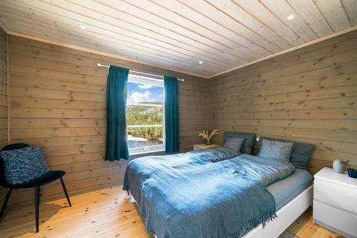 een slaapkamer met houten wanden, een bed en een raam bij Hytte Eribo in Lona