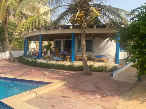 a house with a palm tree and a swimming pool at Yannick House in Nditarh
