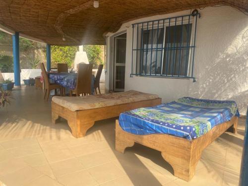 a porch with two beds and a table and chairs at Yannick House in Nditarh