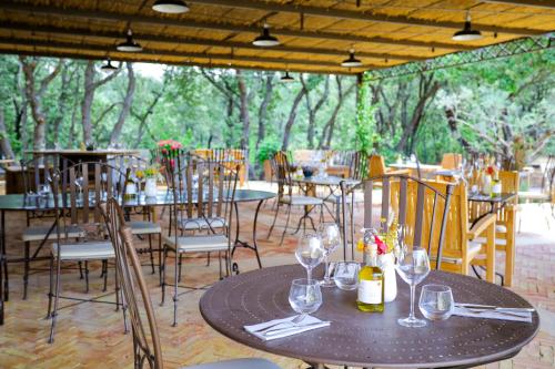 a tables and chairs with wine glasses on a patio at Hotel La Bastide d'Eygalières in Eygalières