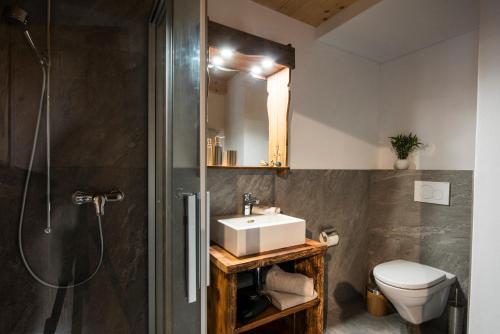 a bathroom with a sink and a shower and a toilet at Ferienhaus Chalet Steckli in Brienz